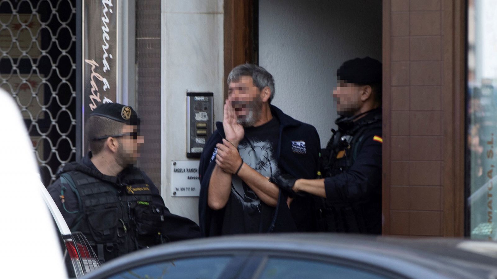 Agentes de la Guardia Civil acompañan a uno de los CDR detenidos durante el registro de un domicilio en Sabadell (Barcelona