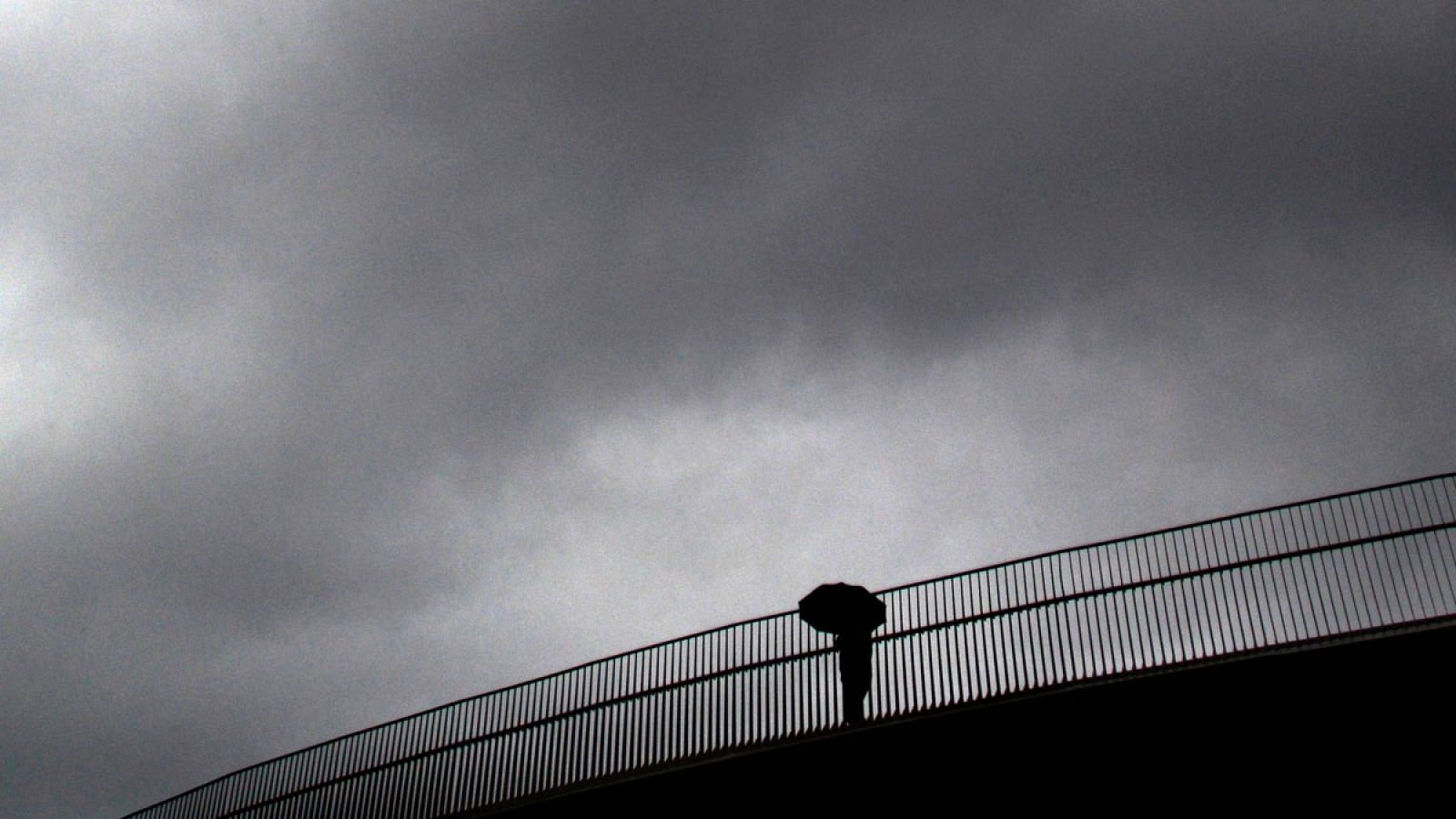 Una persona caminando bajo la lluvia en A Coruña, Galicia.