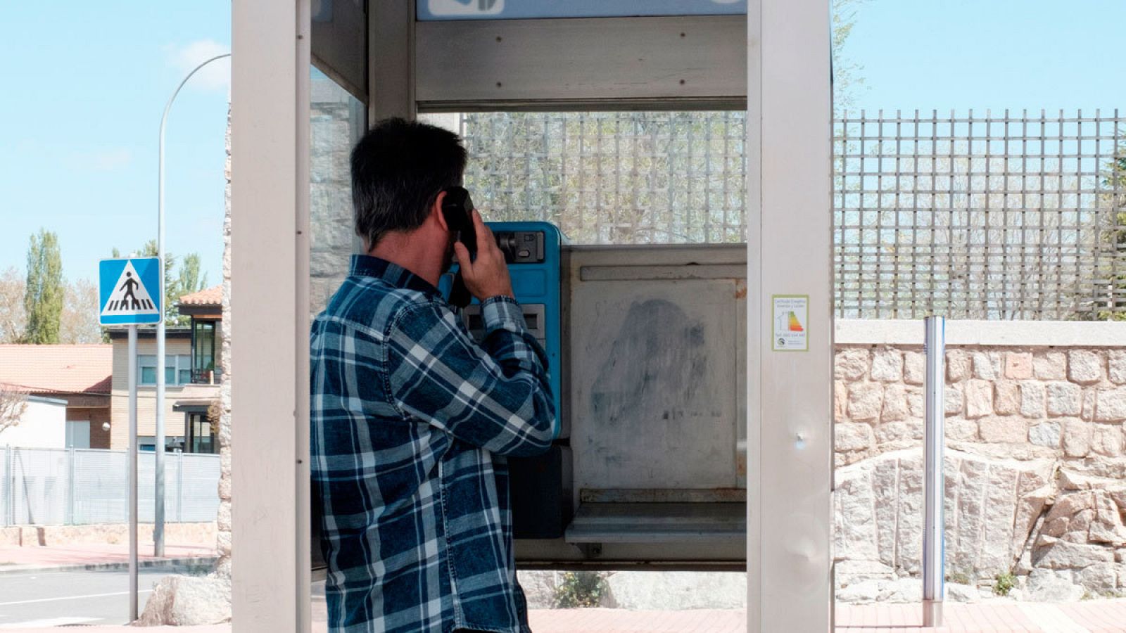 Un hombre utilizando una cabina telefónica en Ávila