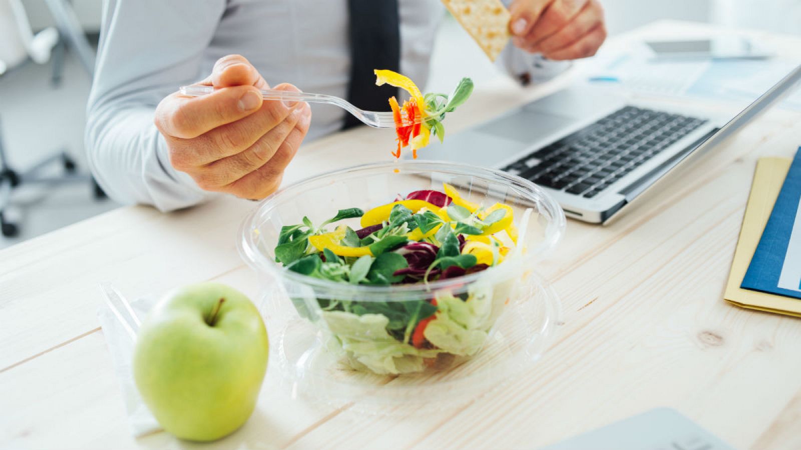 En la imagen, un trabajador consume comida en su puesto de trabajo.