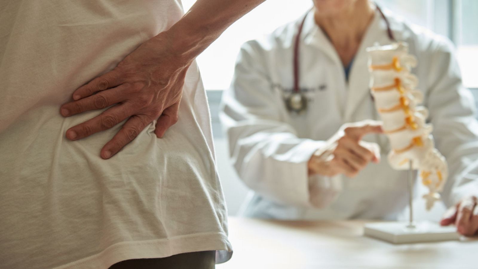 Un médico explica una dolencia de espalda a su paciente en una imagen de archivo