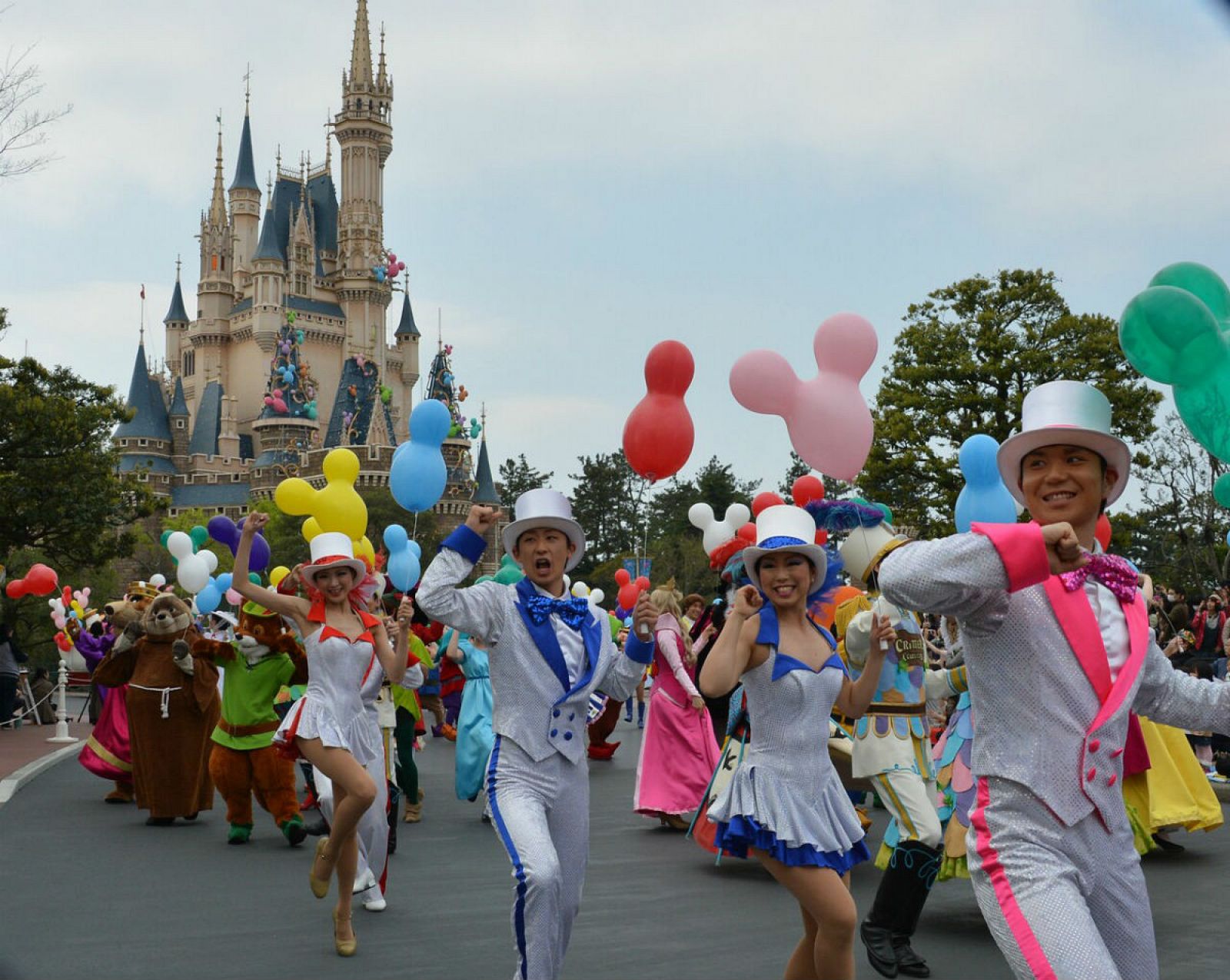 En esta imagen de archivo de 2013, personajes de la franquicia y bailarines desfilan, con el reconocido castillo al fondo.