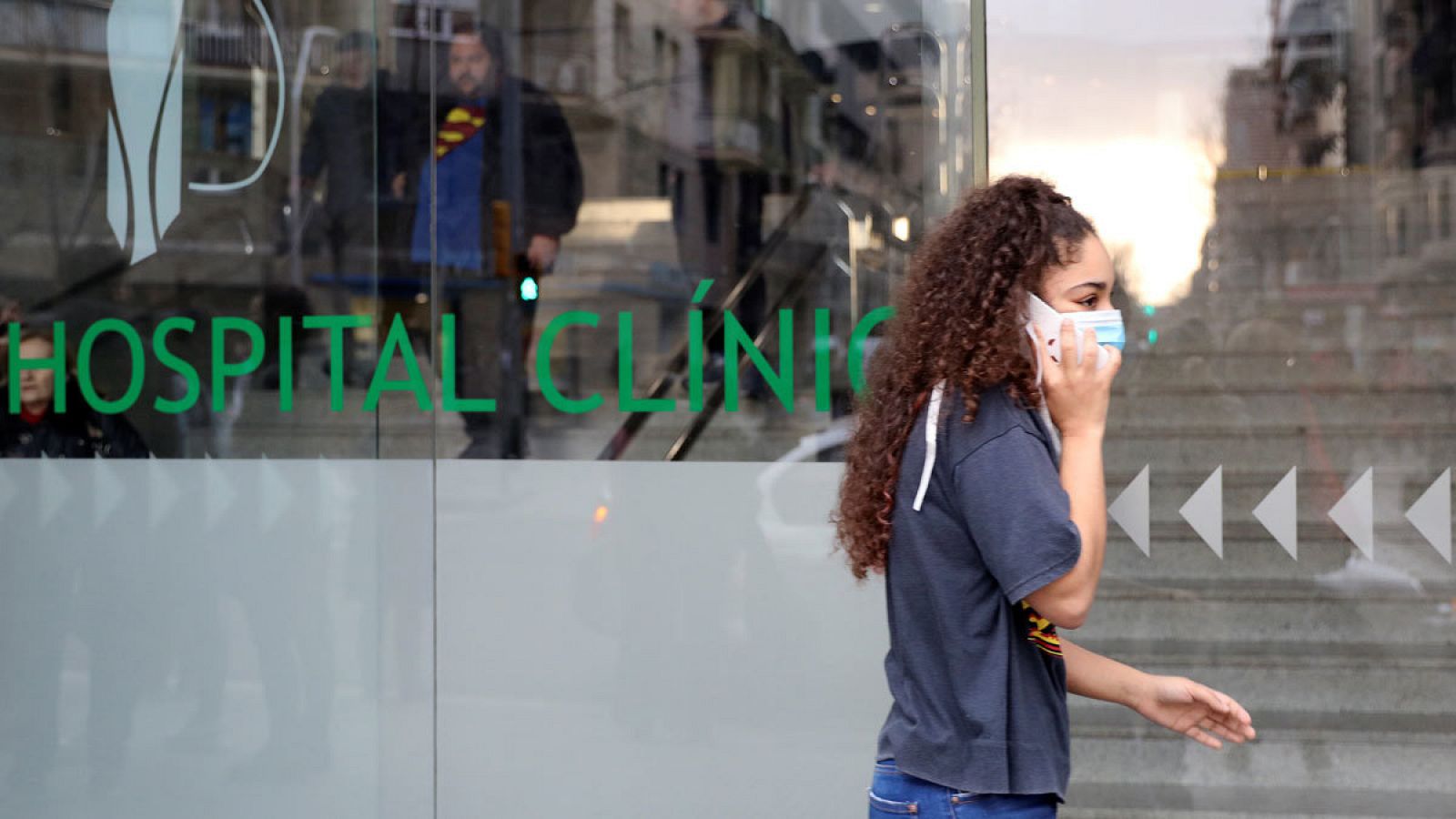 Un mujer con mascarilla pasa junto al Hospital Clinic en Barcelona