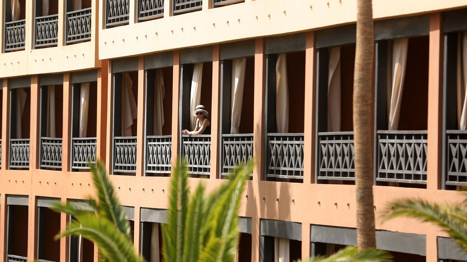 Una turista se asoma al balcón de su habitación, en el hotel situado del sur de Tenerife, que se encuentra en cuarentena tras detectarse cuatro casos de coronavirus