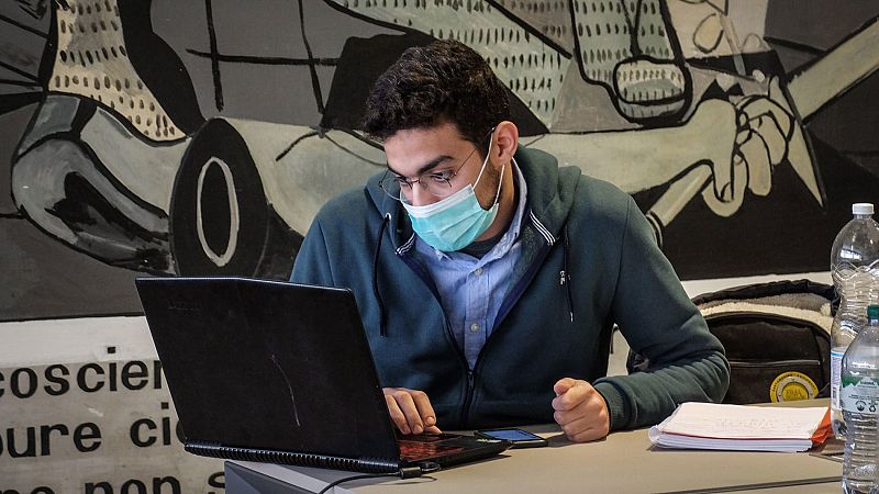Un estudiante de la Universidad Politécnica de Milán se protege con mascarilla mientras estudia