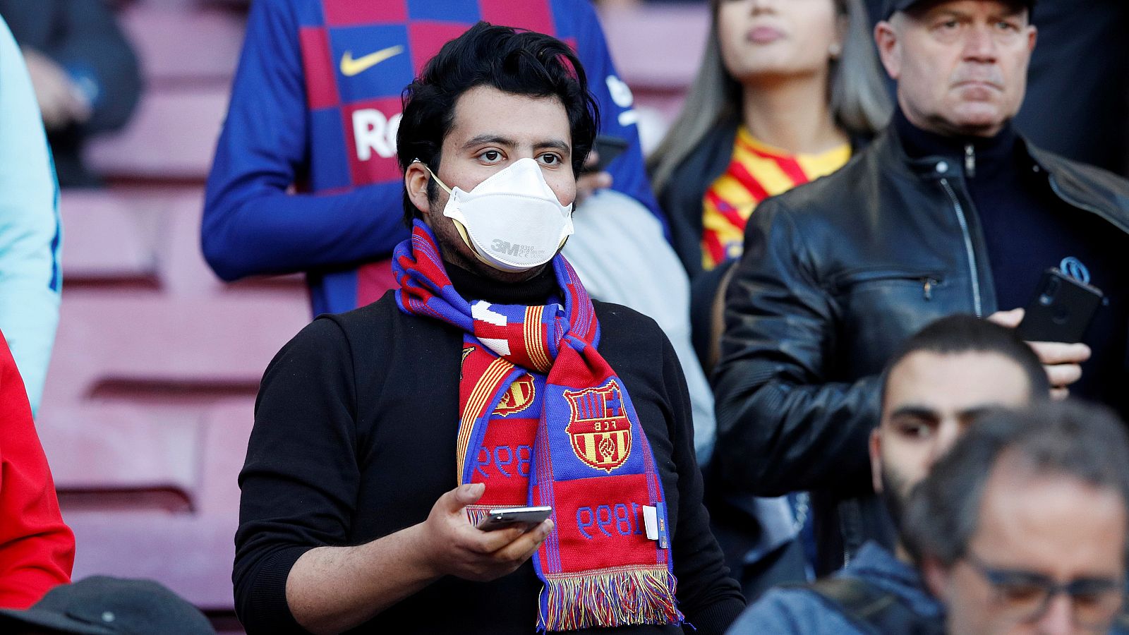 Aficionado del FC Barcelona con mascarilla para evitar la propagación del coronavirus