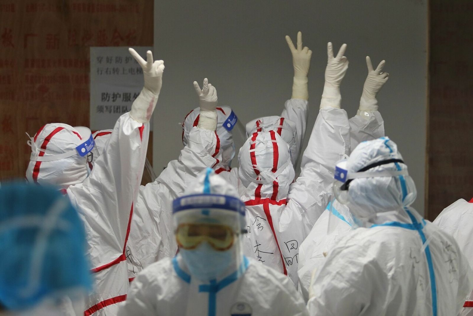 Personal médico dándose ánimos antes de entrar en la UCI en un hospital de Wuhan.