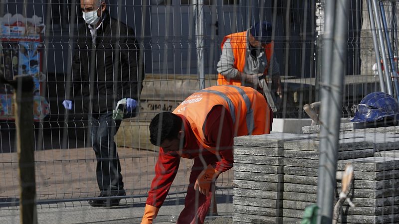 Trabajadores de la construcción urbanizan una calle de Bilbao.
