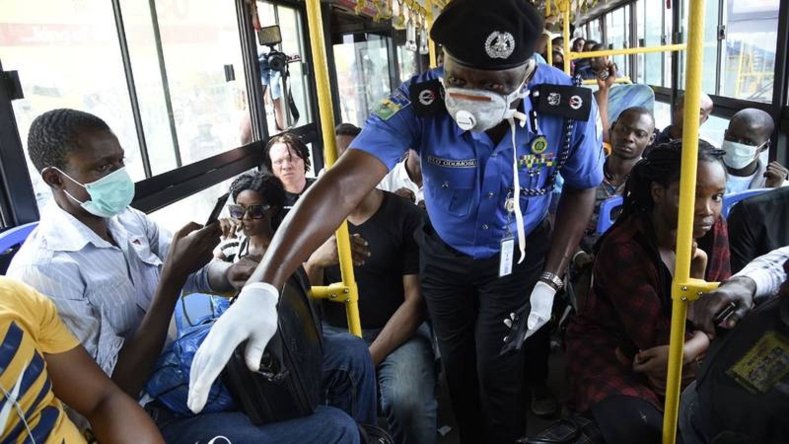  Policía nigeriano supervisando la distancia entre pasajeros por el coronavirus