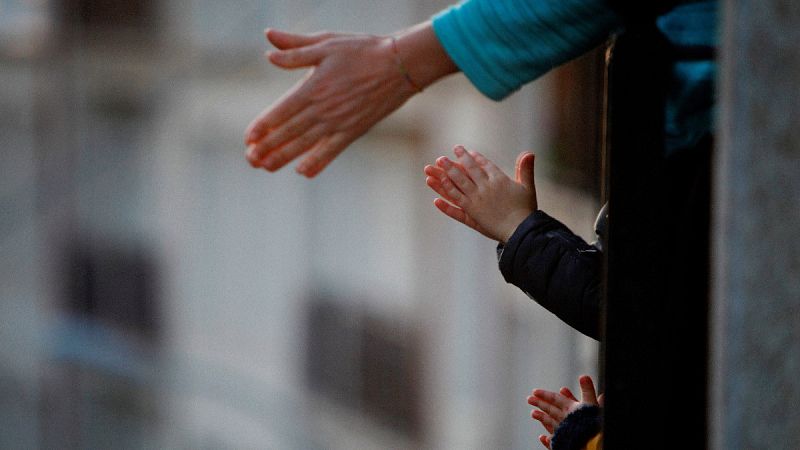 Imágenes de vecinos aplaudiendo a los sanitarios desde la ventana