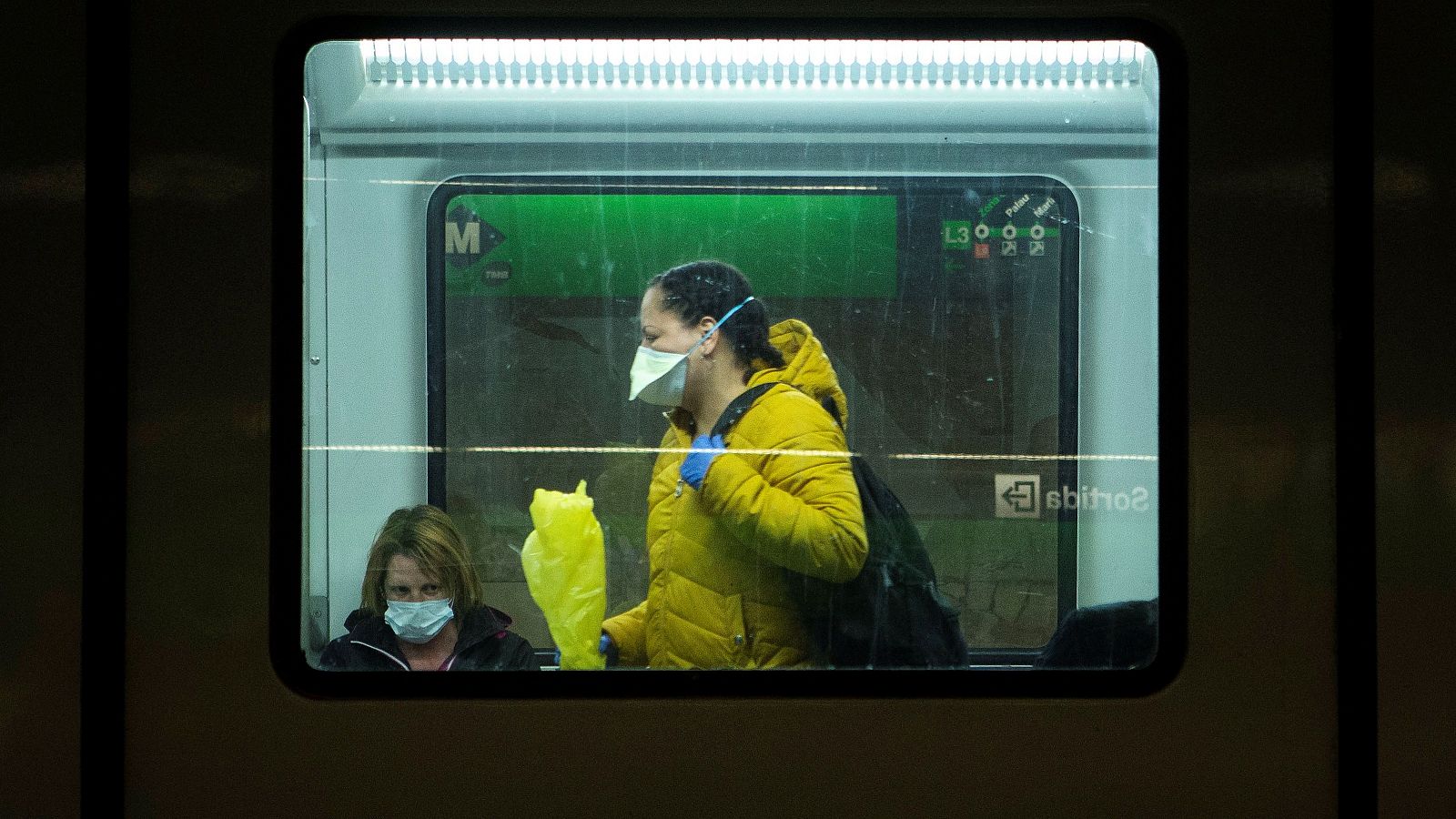Usuarias del metro de Barcelona, con mascarillas protectoras.