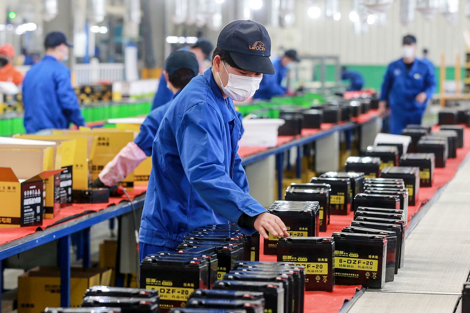 Imagen de gente trabajando en una fábrica de baterías en Huaibei, China. 