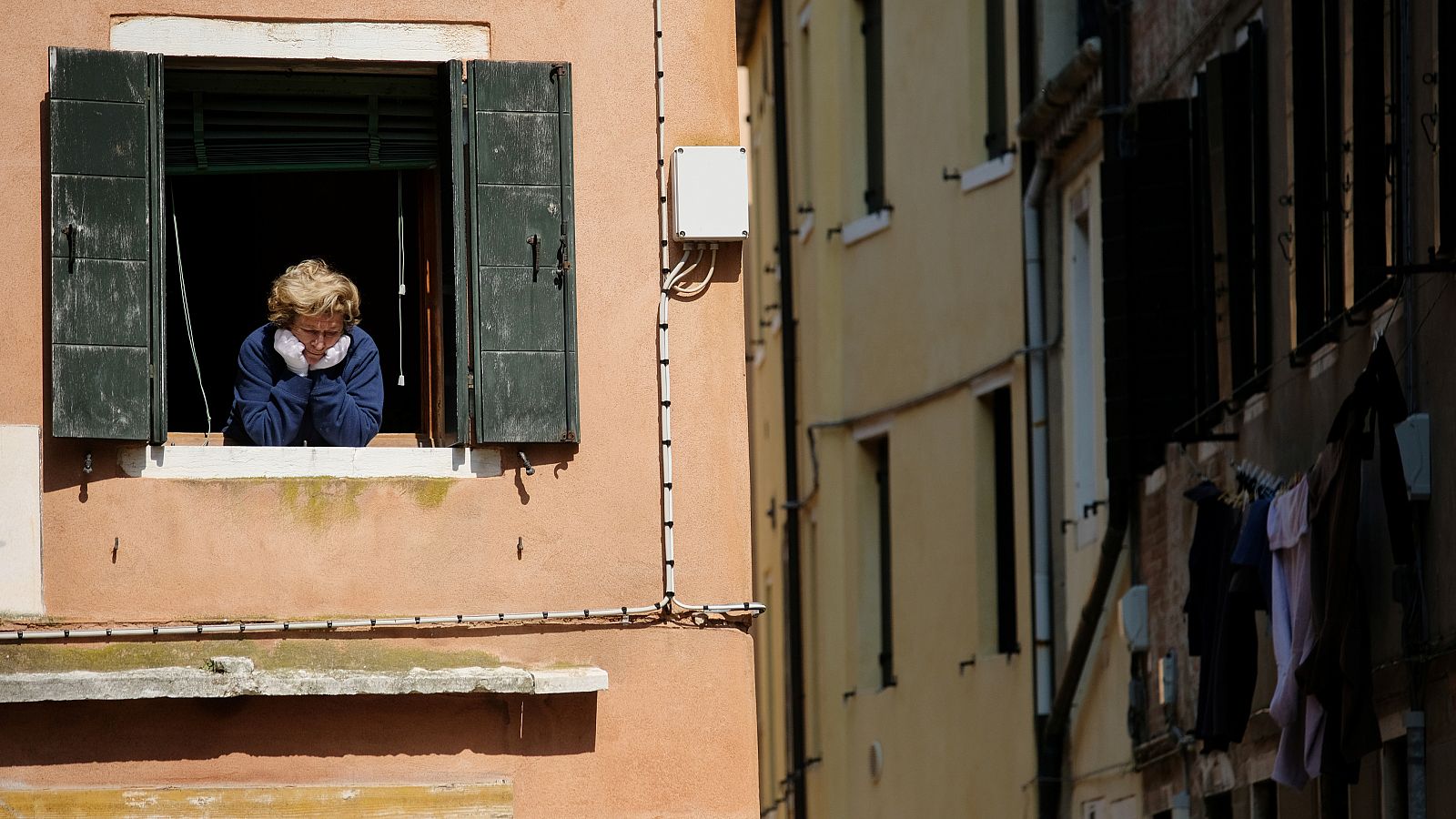 Coronavirus Italia: Una mujer asomada a la ventana de una vivienda en Venecia.