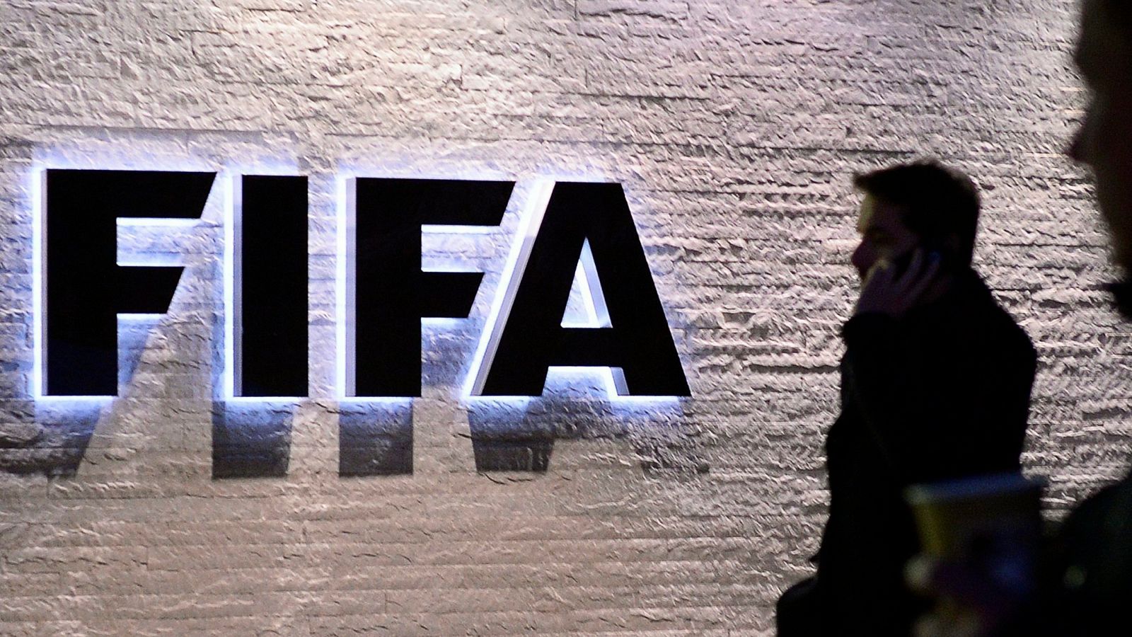 Varios periodistas permanecen a la entrada de la sede de la FIFA en Zúrich, Suiza