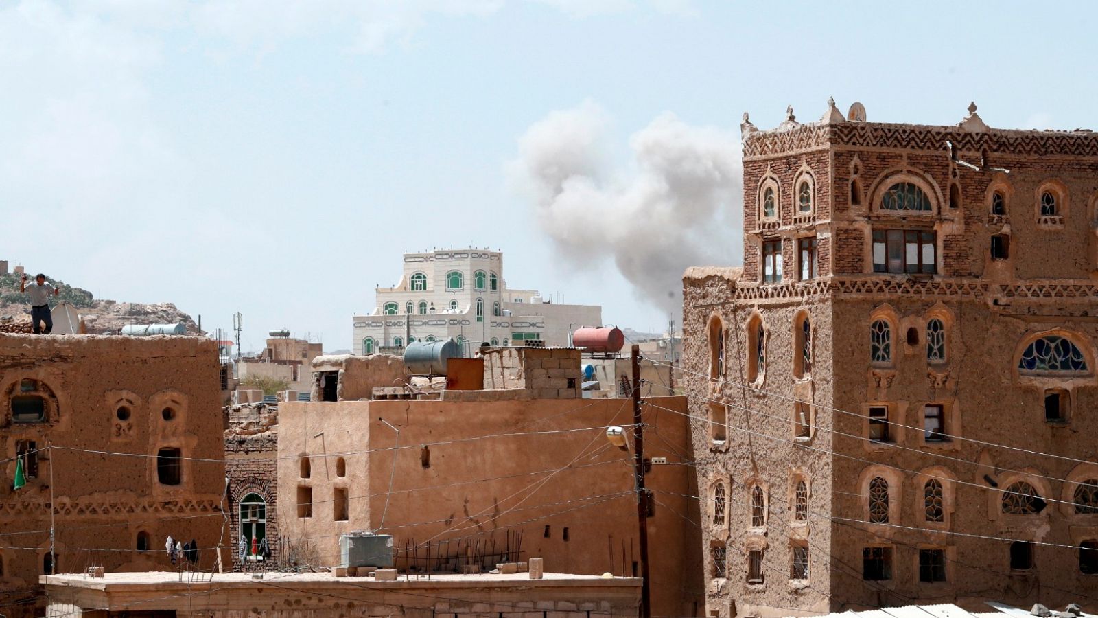 El humo asoma sobre las casas tras un ataque aéreo en Sanaa