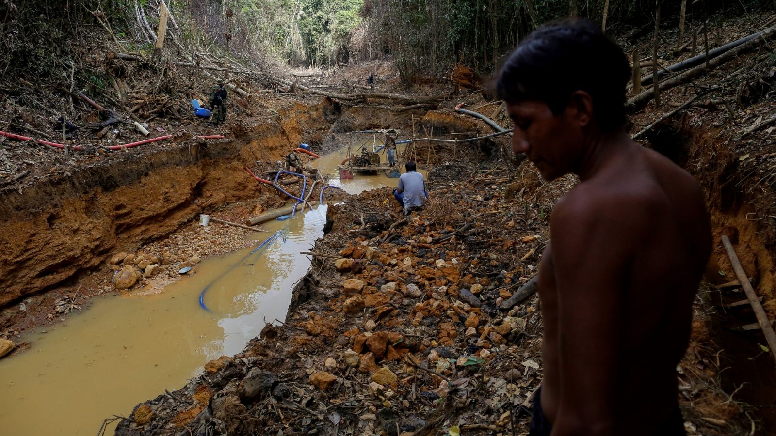 Un indio yanomami sigue a agentes de la agencia ambiental de Brasil en una mina de oro