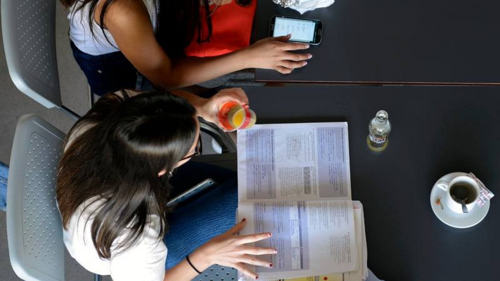 Dos estudiantes preparan un examen en la cafetería de la facultad