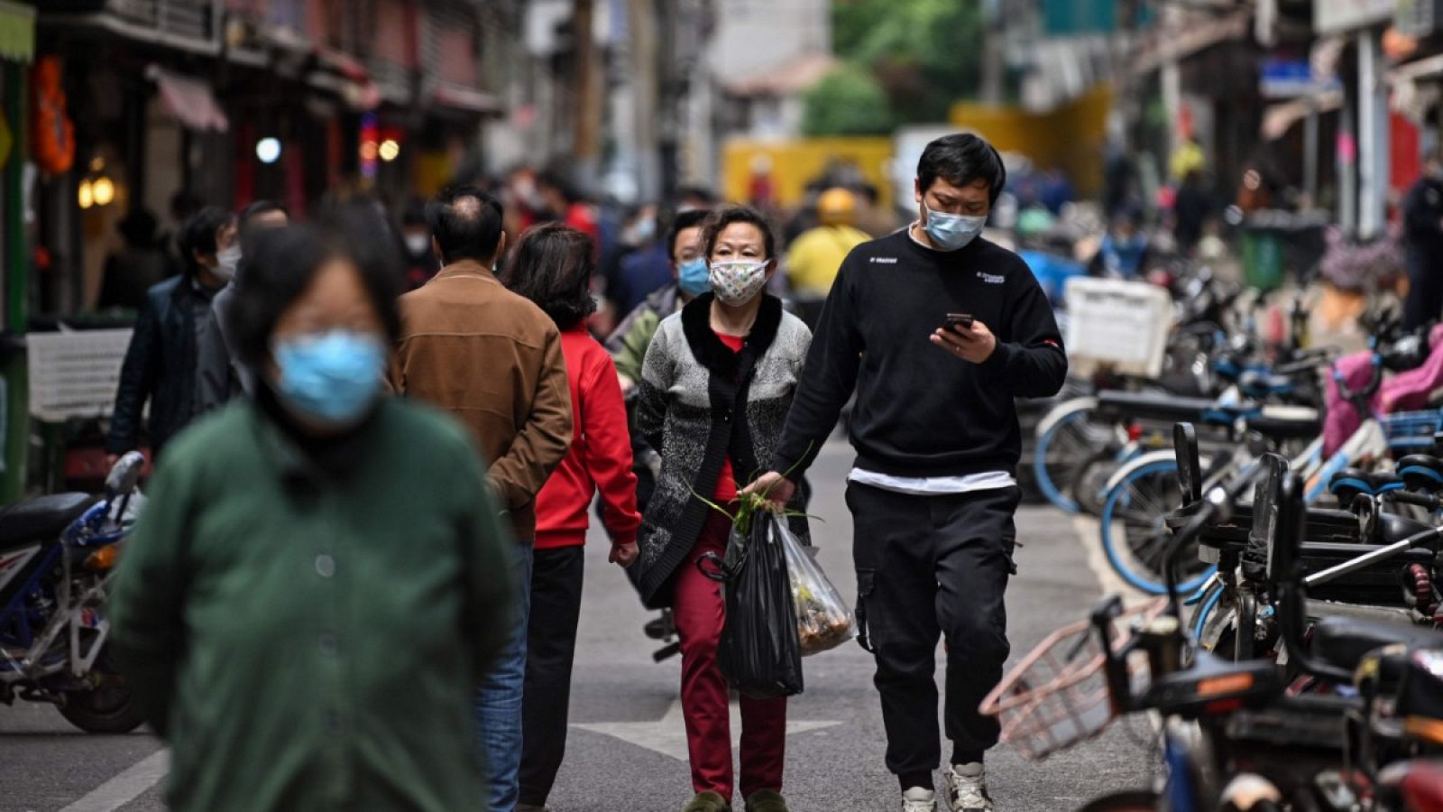 Gente con mascarillas paseando por una calle de Wuhan.