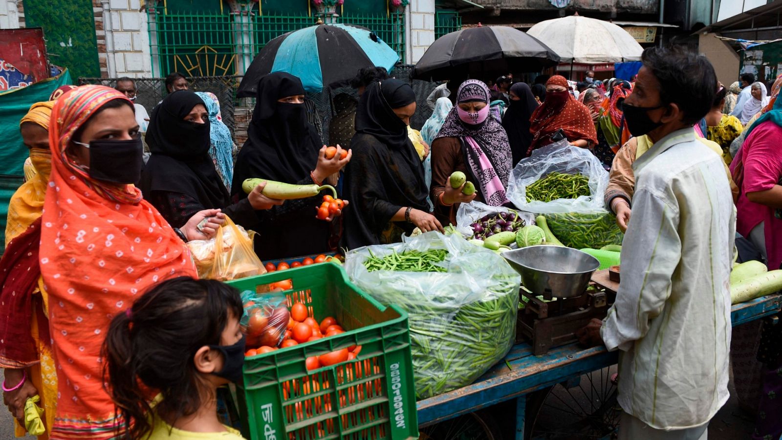 La gente compra verduras en un mercado duranteen Ahmedabad, India