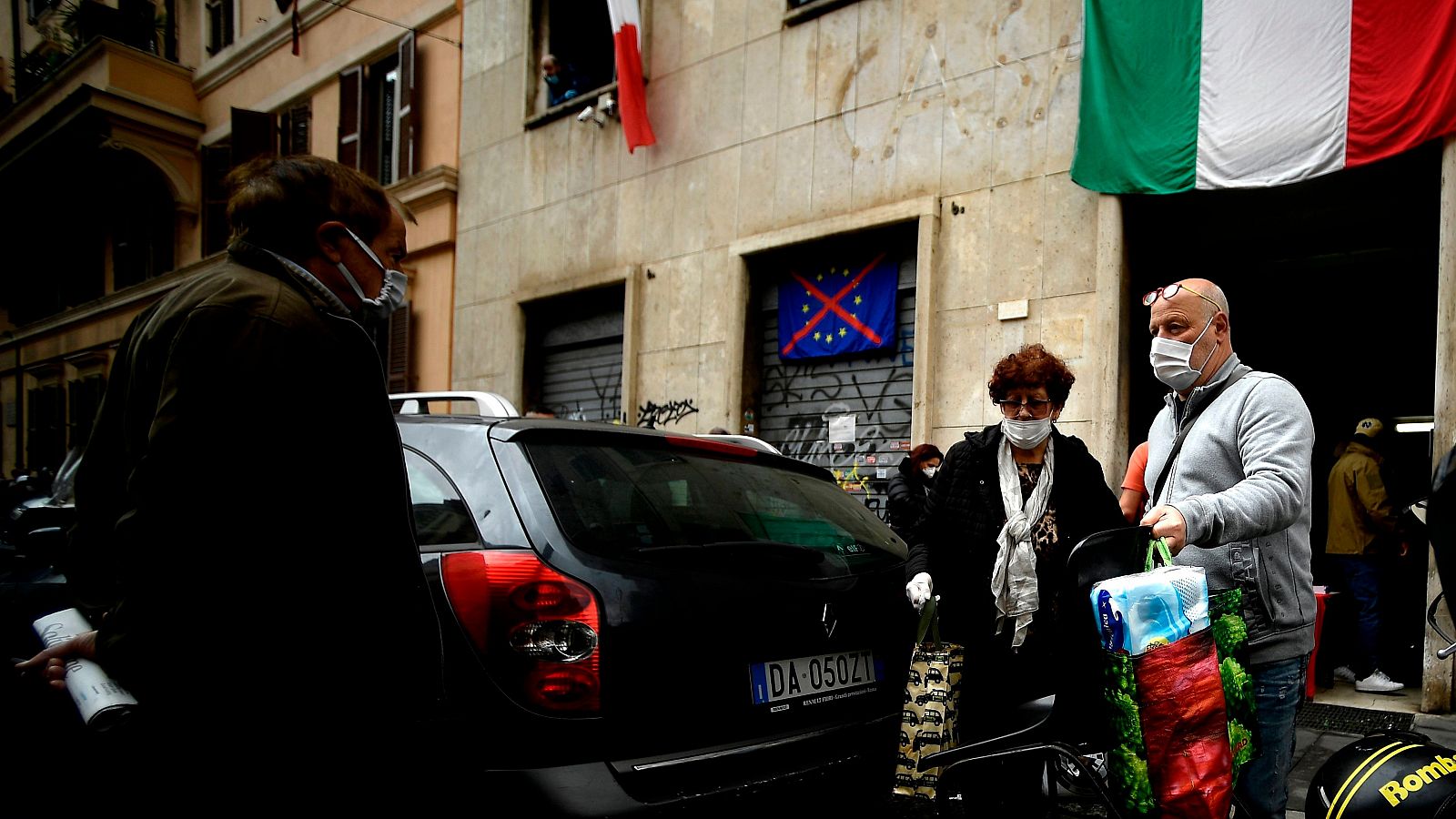 Coronavirus en Italia: Una familia lleva bolsas con la compra facilitadas por activistas del movimiento neofascista CasaPound, en Roma.