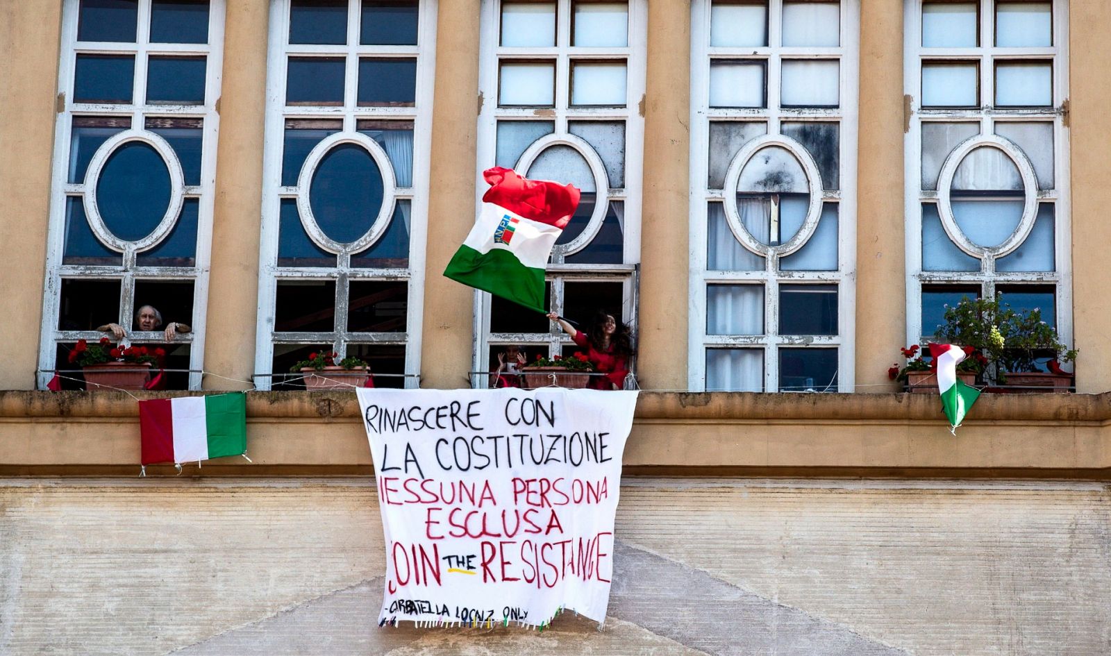 Una mujer celebra el Día de la Liberación en el balcón de su casa en Roma