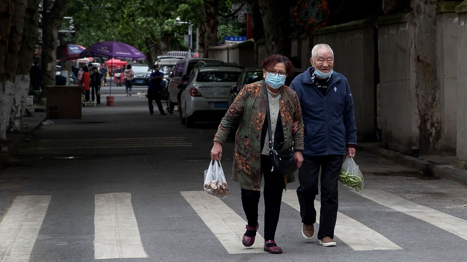 Dos personas cargan con las compras en Wuhan, China