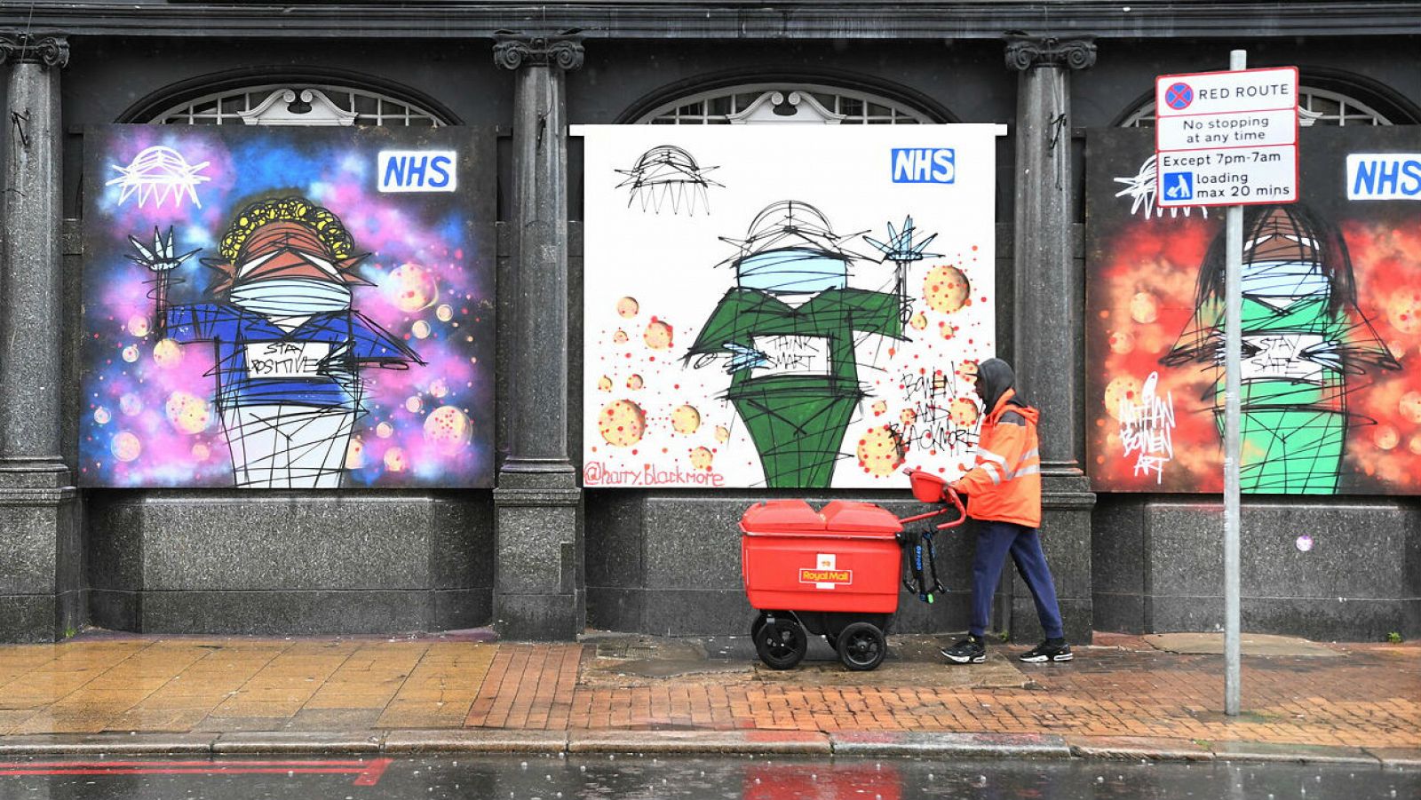 Un trabajador de Royal Mail pasa las obras de arte en apoyo del NHS (Servicio Nacional de Salud) en Londres, Reino Unido.