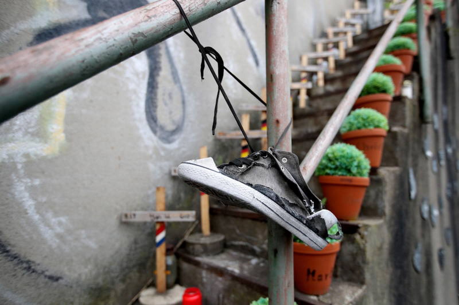 Una zapatilla rota cuelga en una valla en el memorial por las víctimas del Loveparade