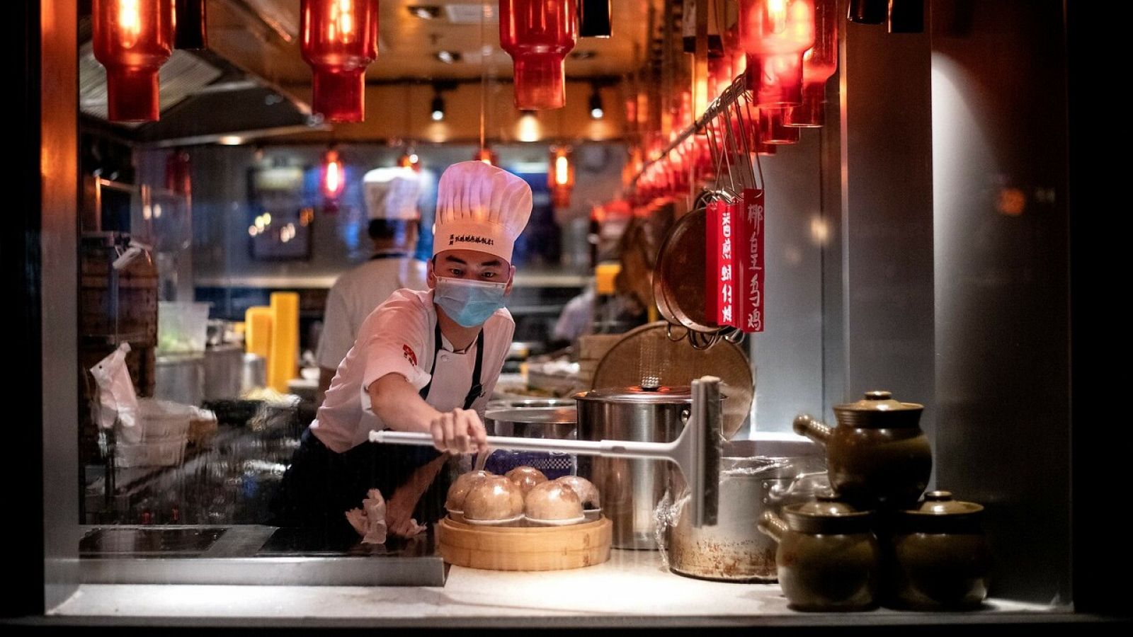 Un empleado limpia la ventana del restaurante en Shenzhen, China