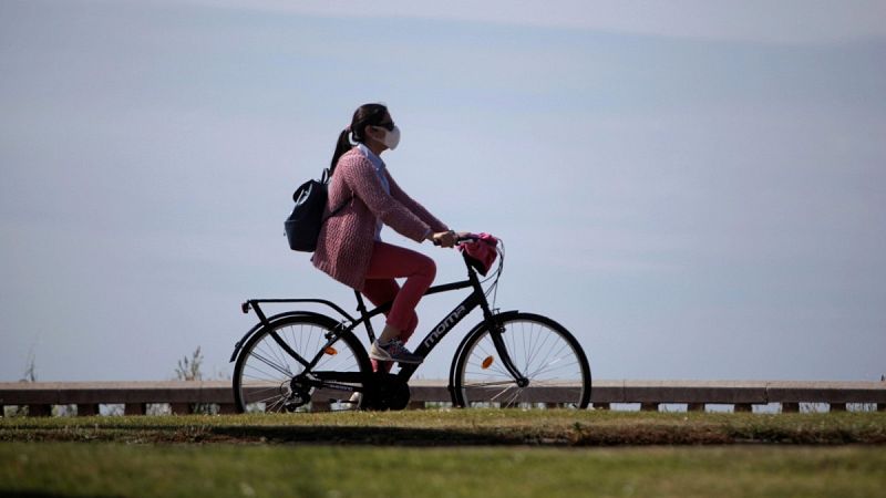 Una mujer con mascarilla circula en bicicleta por A Coruña
