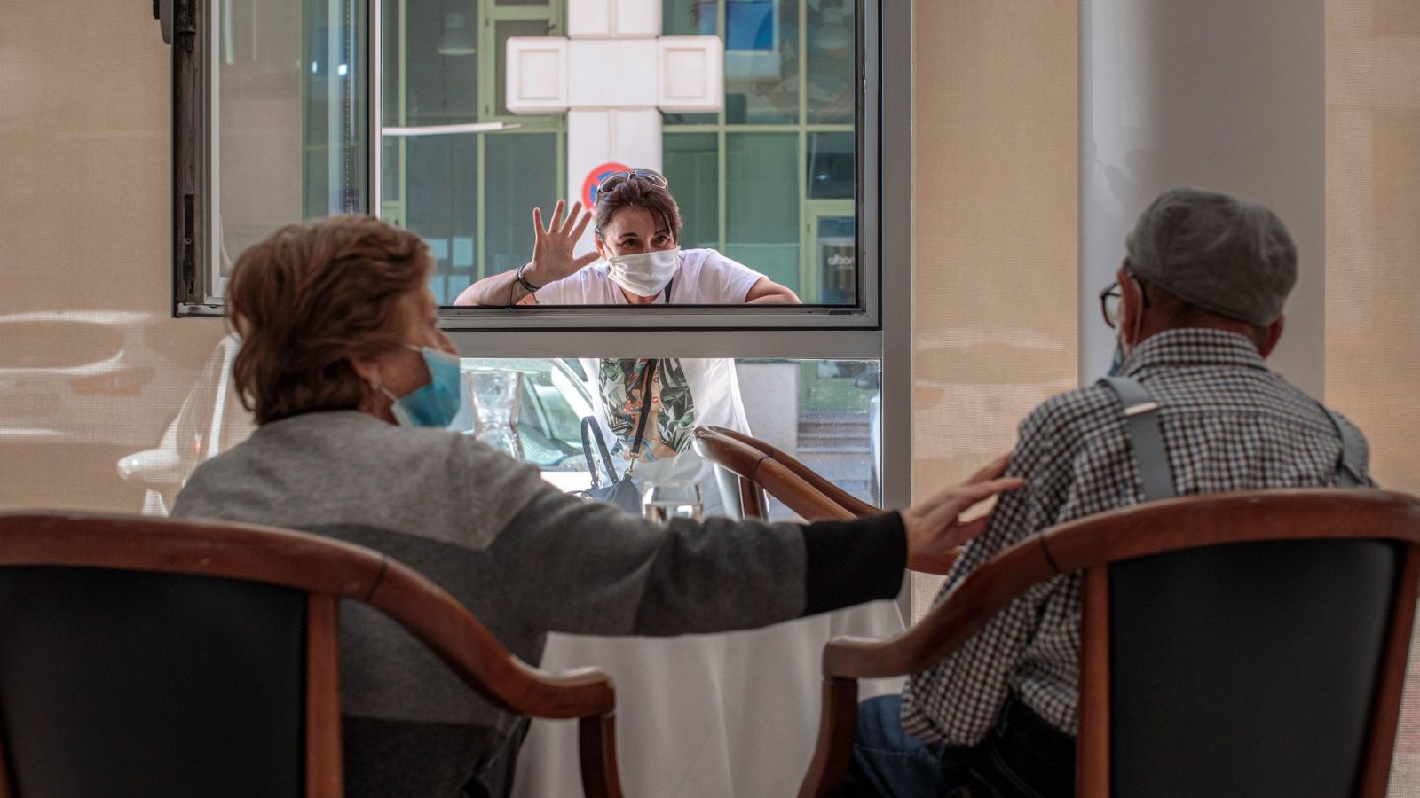 Una mujer conversa con sus padres a través de una ventana habilitada en la residencia de mayores Ballesol Patacona, en Valencia, para que los residentes puedan recibir visitas de sus familiares.