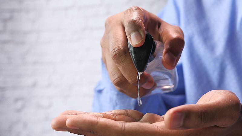 Manos de hombre manipulando gel hidroalcohólico.
