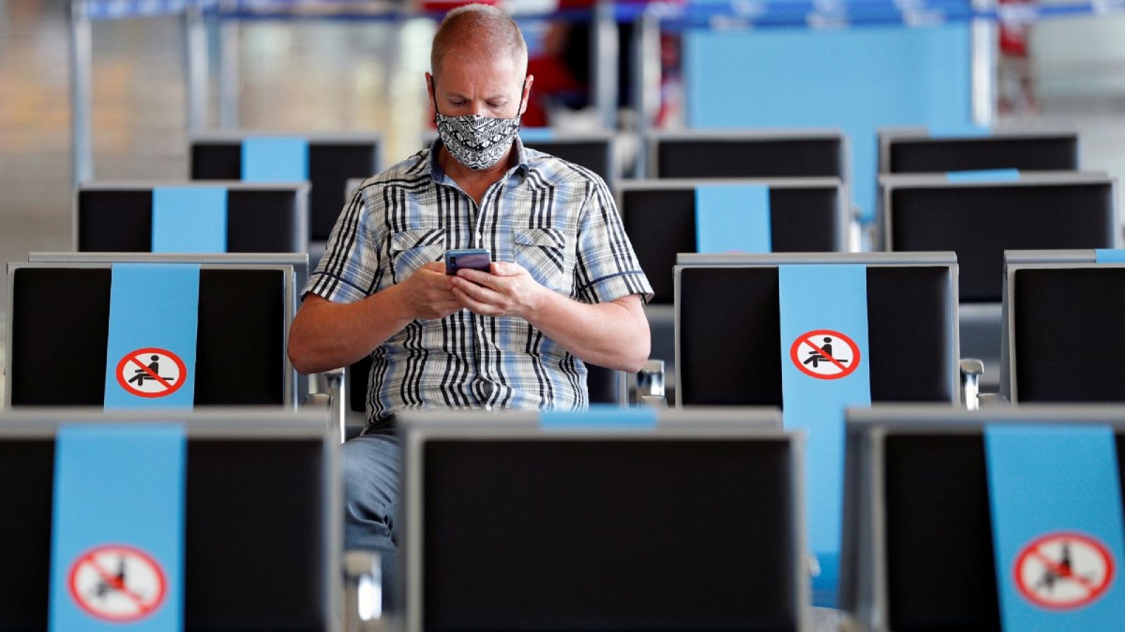 Un viajero espera con mascarilla en el aeropuerto de Fuimicino, en Roma, Italia