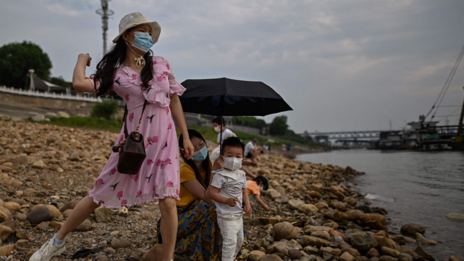 Un grupo de personas con mascarillas en la orilla del río Yangtze en Wuhan, China.