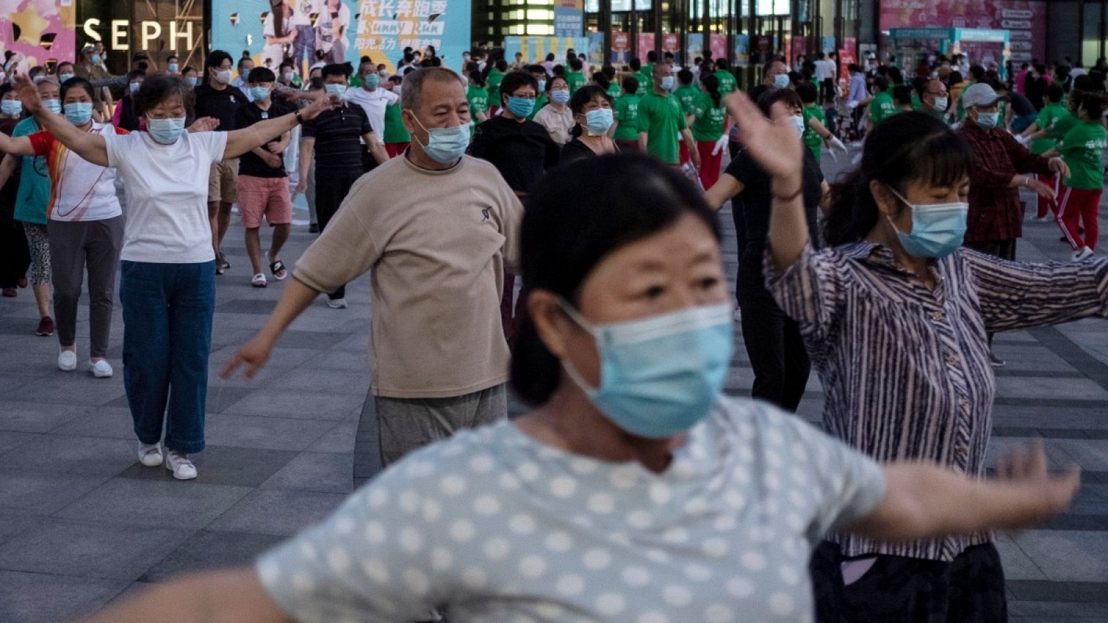  Un grupo practica deporte en un centro comercial de Pekín, con mascarillas y guardando cierta distancia
