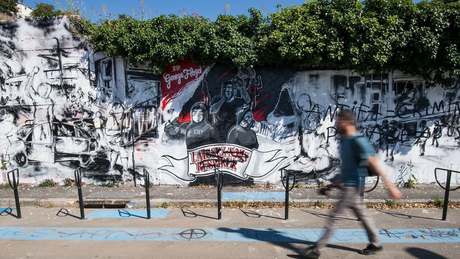 Un peatón camina ante un mural que homenajea al fallecido George Floyd