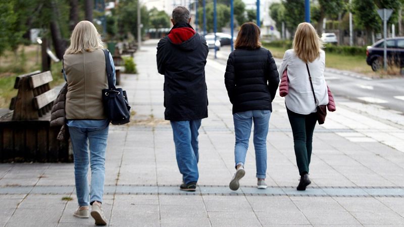 Varias personas dan un paseo en la tarde del jueves por la localidad coruñesa de Cabanas