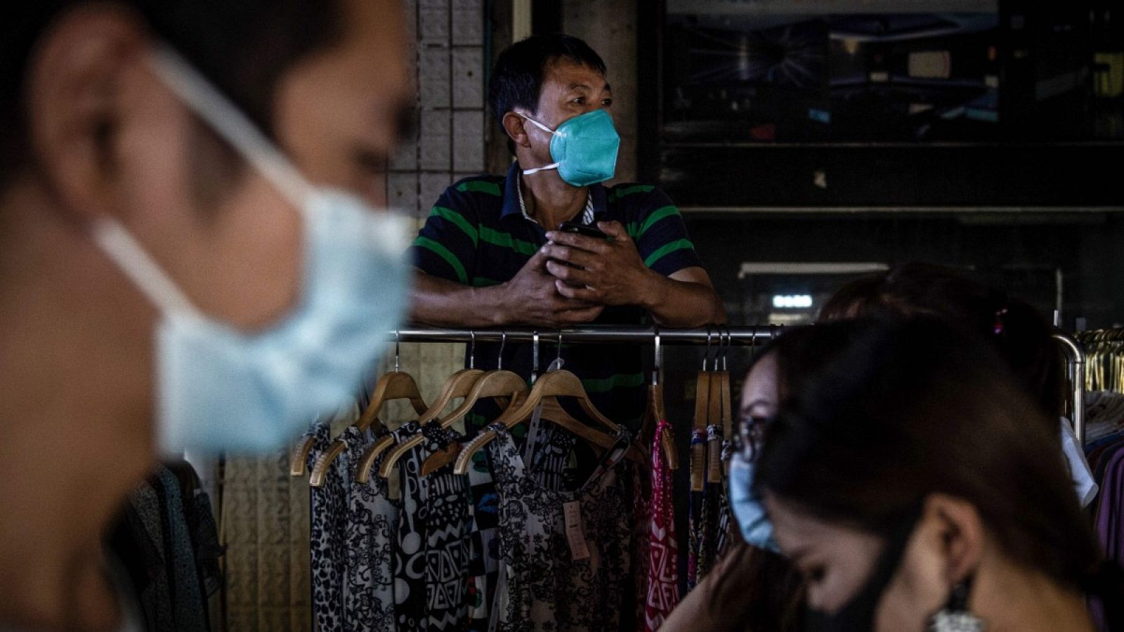 Imagen de gente con mascarilla en un mercado de Wuhan, China.