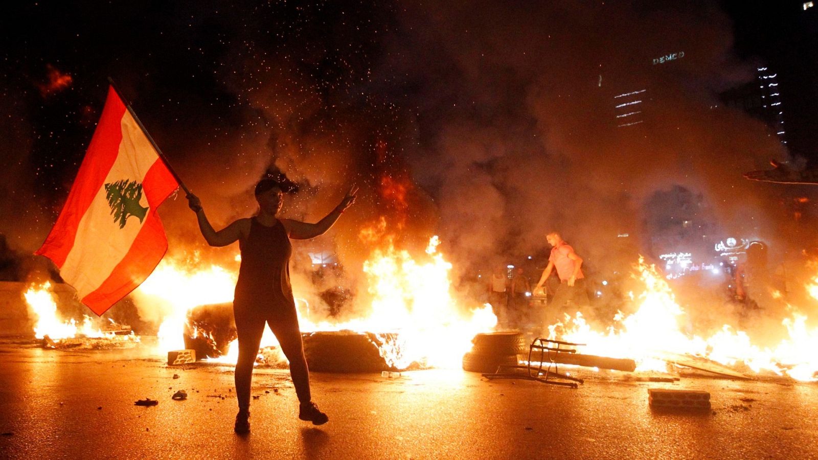 Una manifestante antigubernamental porta una bandera libanesa en Beirut