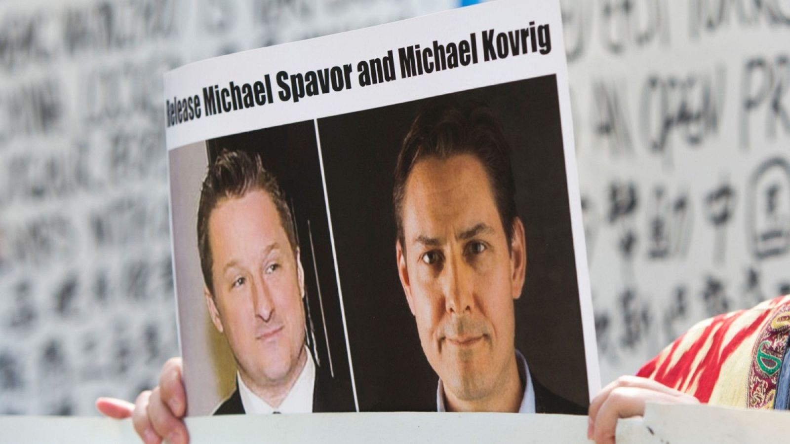 Un representante de la Asociación de Uigures de Vancouver se manifiesta en contra del tratamiento de los uigures por parte de China mientras sostiene una foto de los canadienses detenidos Michael Spavor y Michael Kovrig.