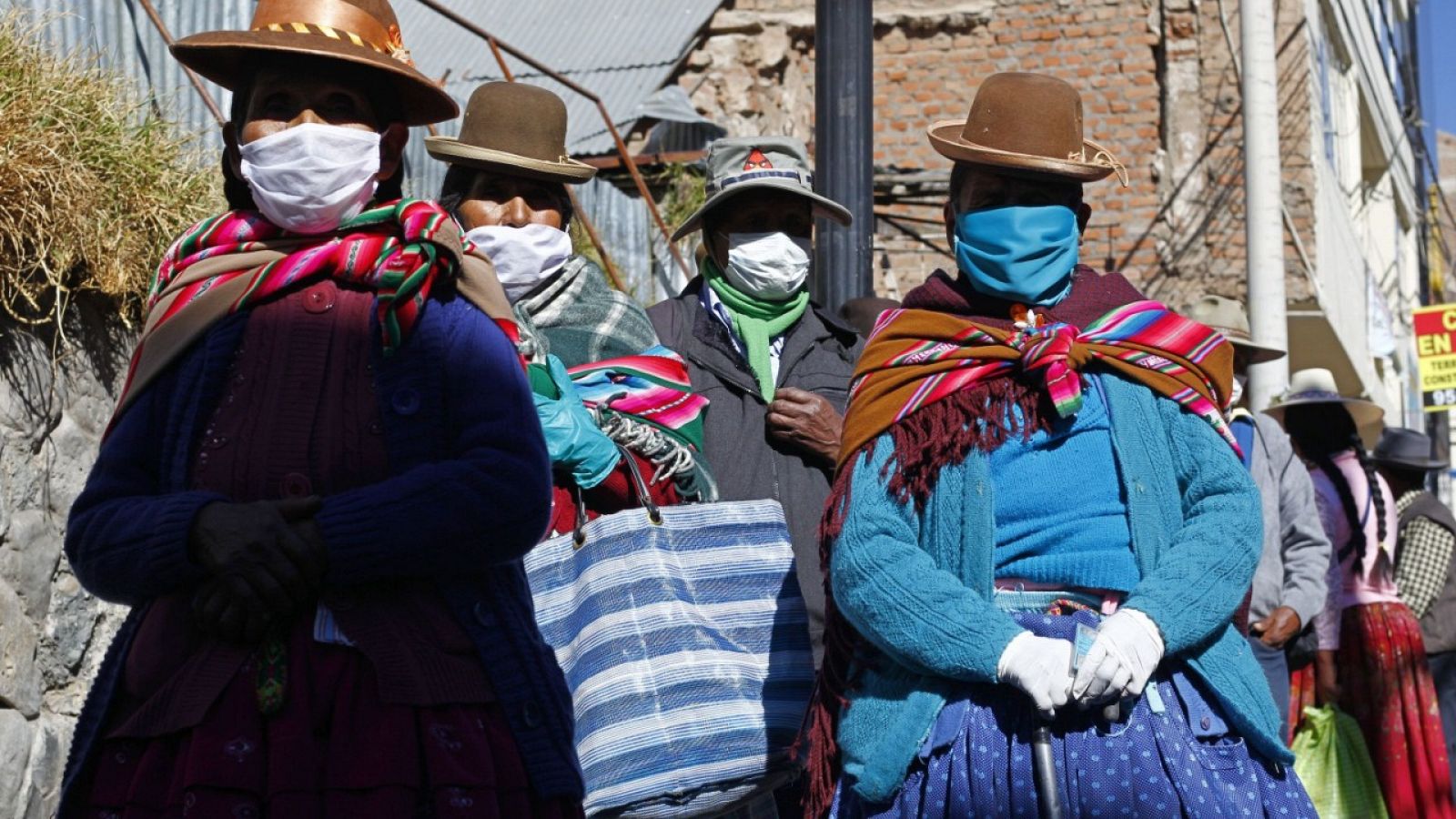 Gente con mascarilla esperando para recibir un bono de ayuda en Puno, Perú.