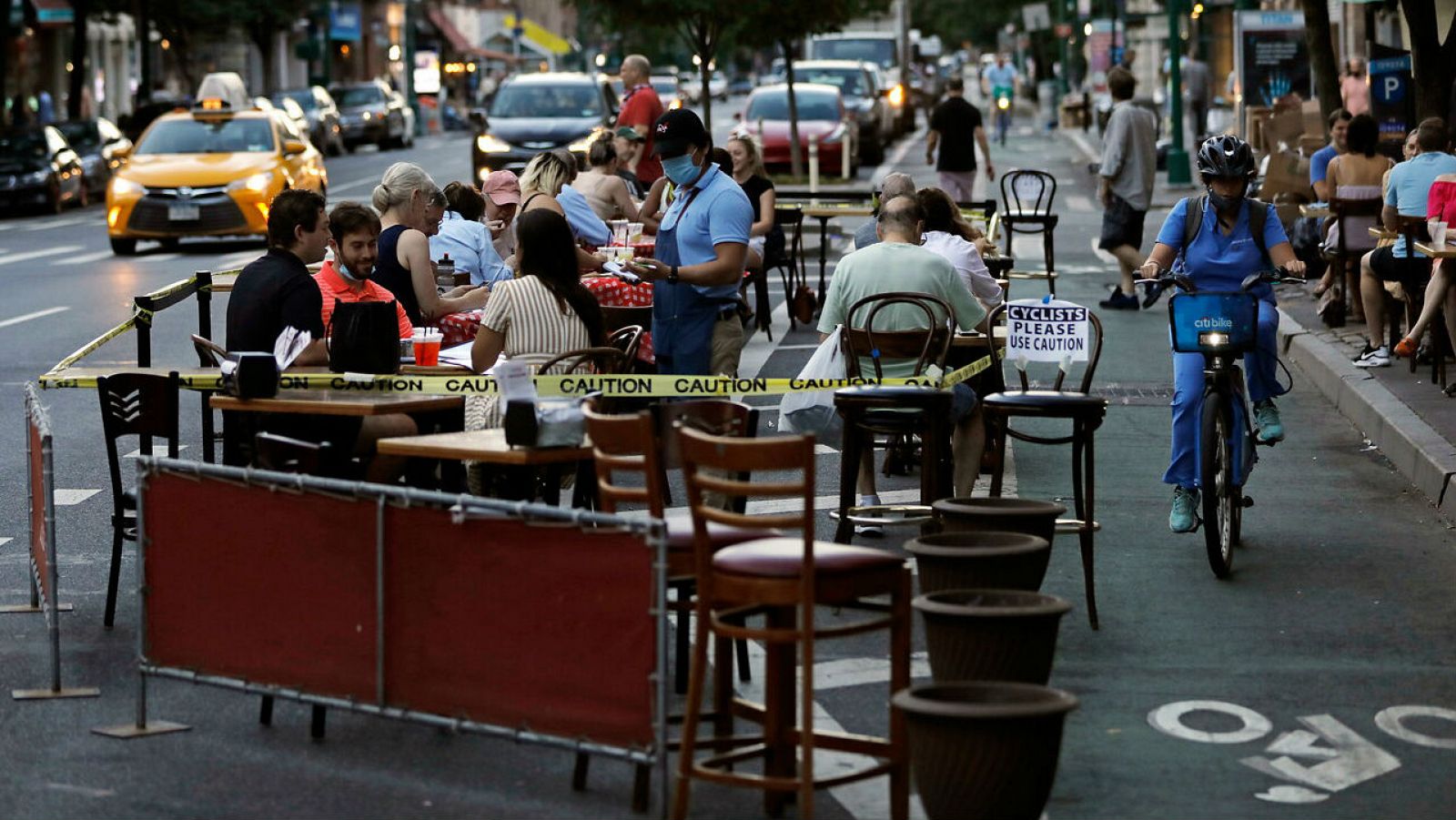 Personas cenan en una terraza en Columbus Avenue en Nueva York, Nueva York, EE. UU.