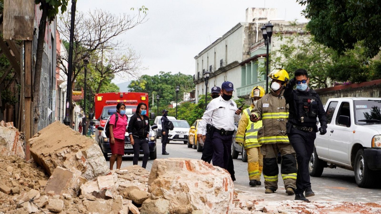 Miembros de la policía y de los bomberos observan los daños causados por el terremoto de 7,5, en la ciudad de Oaxaca (México).