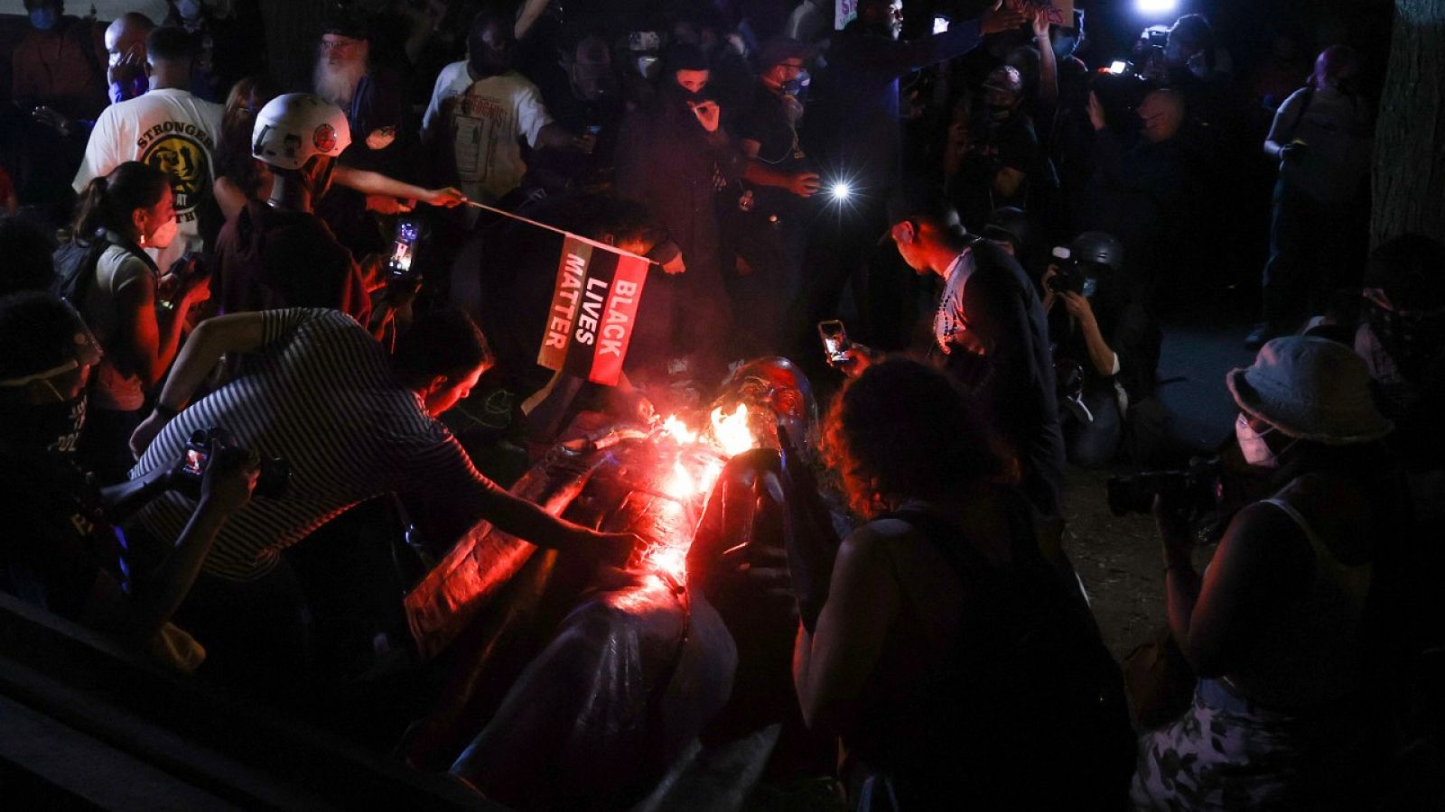 Manifestantes prendiendo fuego a la estatua derribada de Albert Pike el 19 de junio de 2020 en Washington.