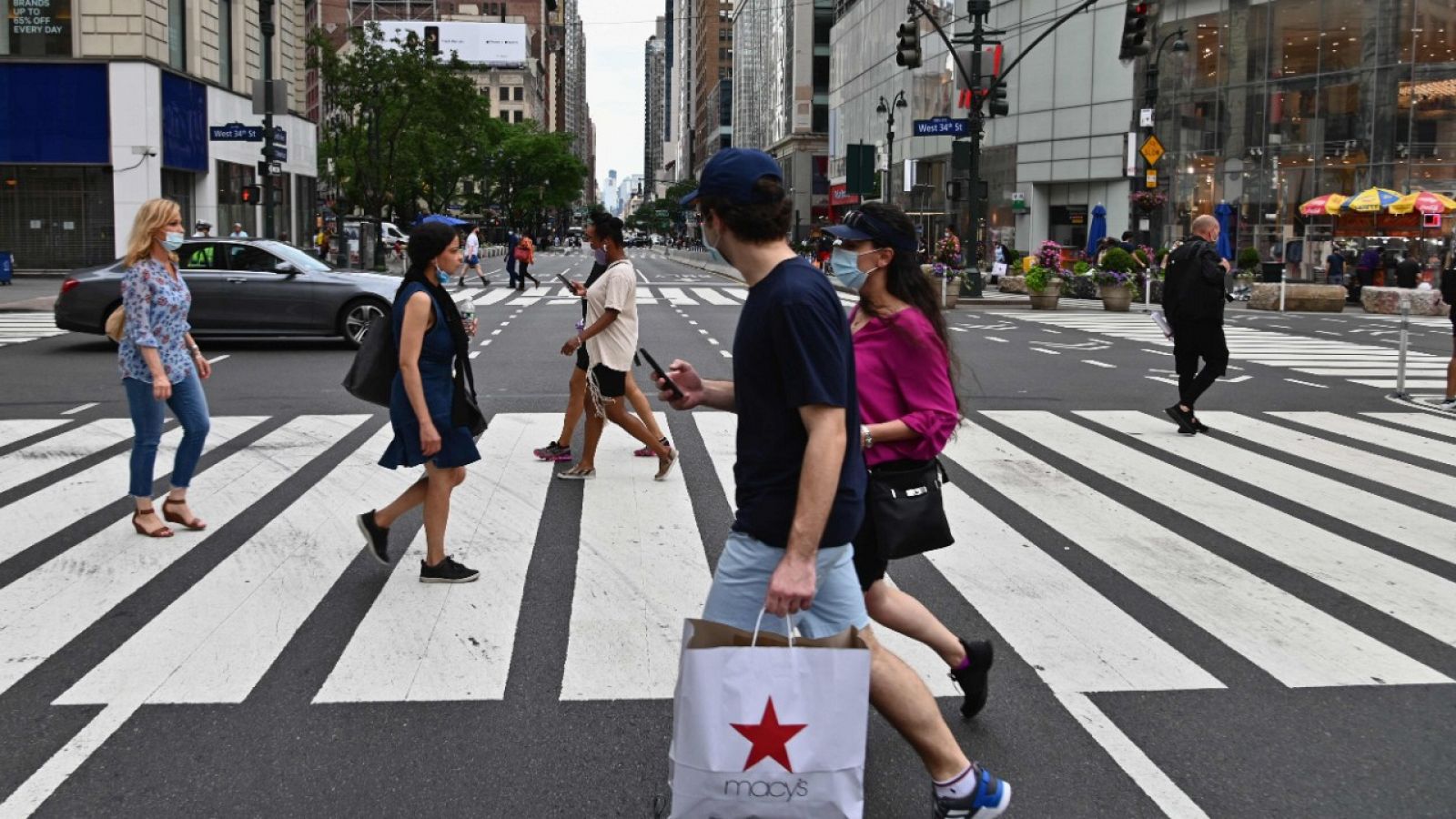 Gente con mascarilla cruzando por un paso de cebra de una calle de Nueva York.