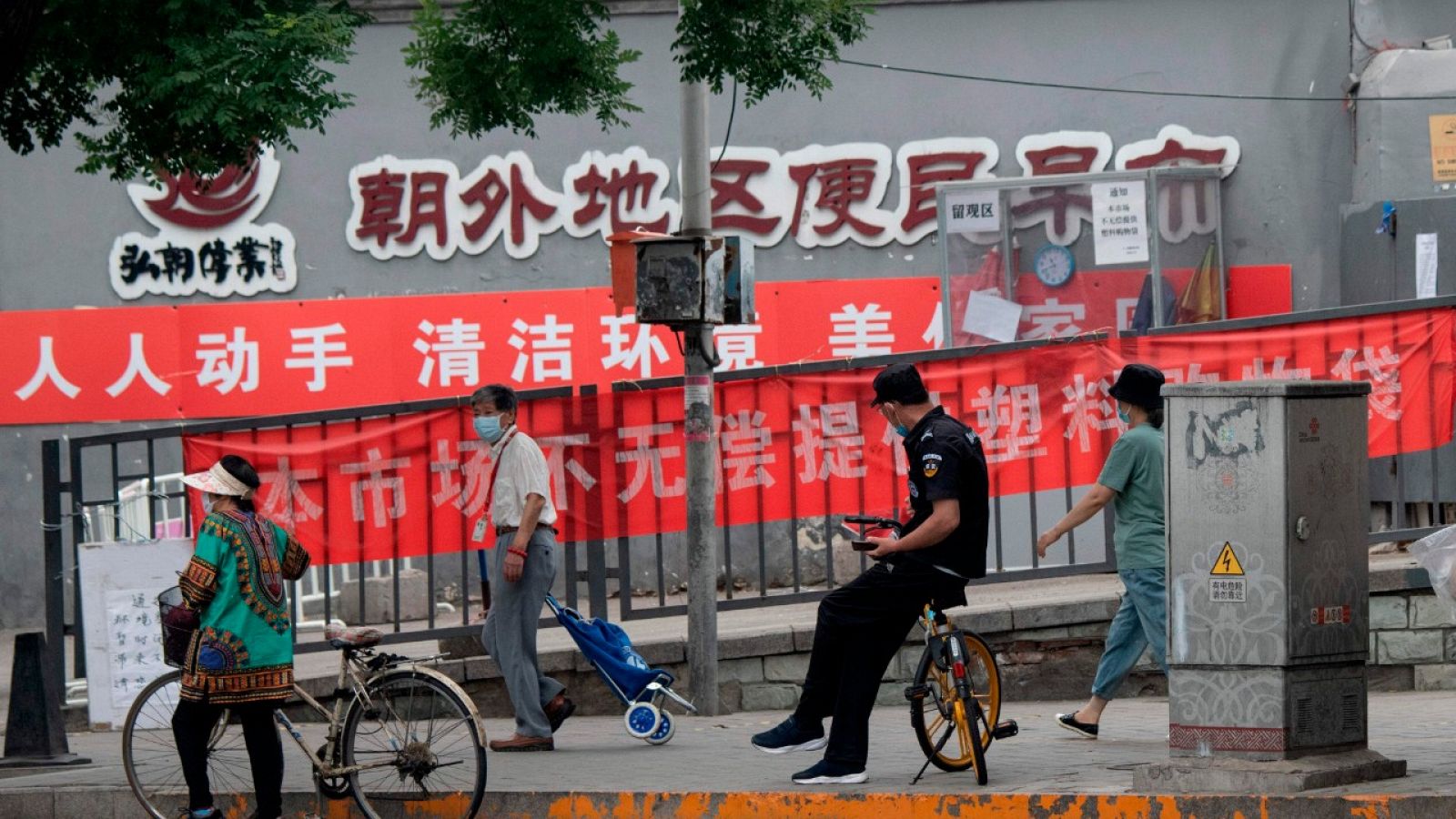 Gente caminando frente a la fachada de un mercado de Pekín.