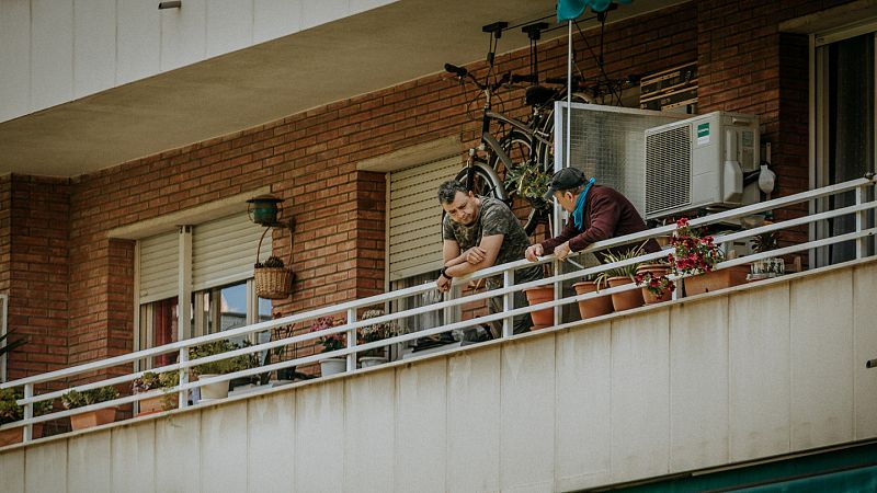 Vecinos charlan en el balcón durante el confinamiento en Barcelona.