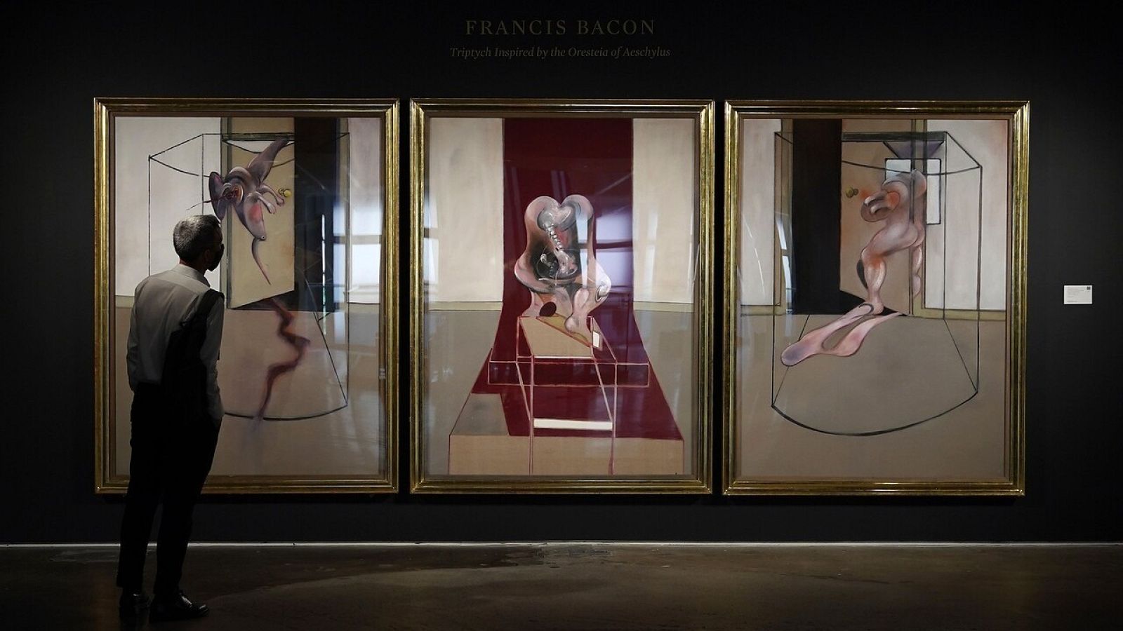  Un hombre mira "Tríptico inspirado en la Orestíada de Esquilo", de Francis Bacon