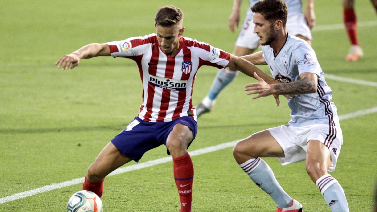 El centrocampista del Atlético de Madrid, Marcos Llorente (i), controla el balón ante el defensa del Celta de Vigo, Jorge Sáenz.