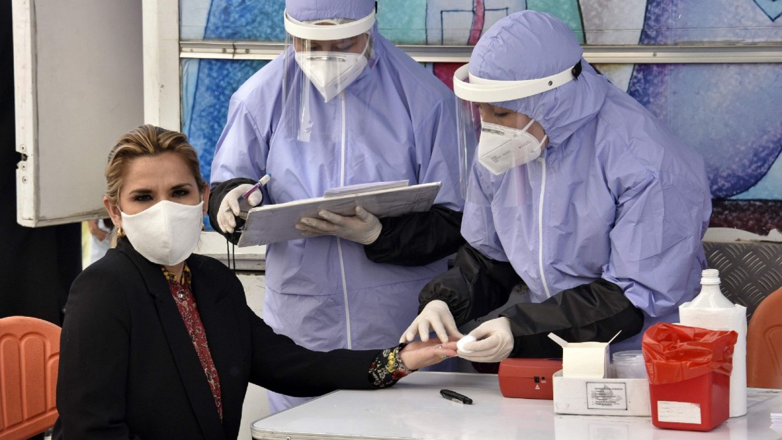 La presidenta boliviana Jeanine Anez se hace un análisis de sangre antes de donar sangre el Día del Donante de Sangre, en el palacio presidencial de La Paz durante la pandemia, en junio